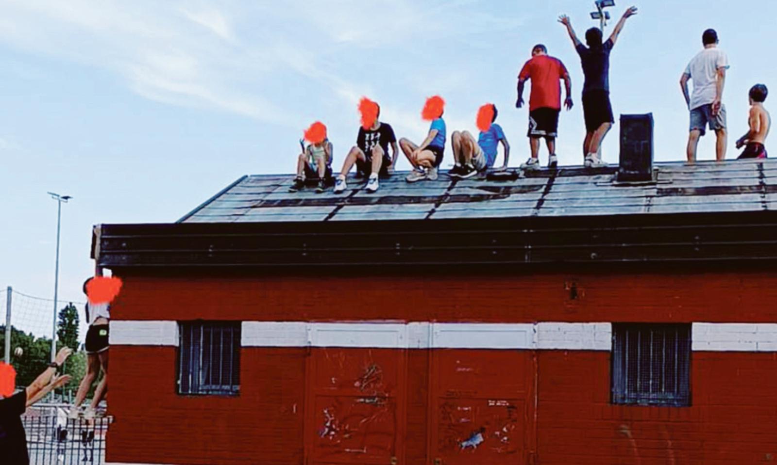 Bambini salgono sul tetto aiutati dagli adulti